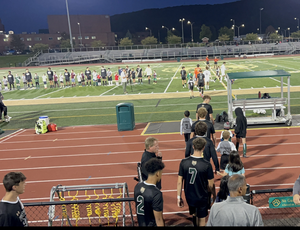 (Pictured above-Vestal varsity soccer boys leading 
members of Vestal youth soccer teams onto the 
field during youth night)
